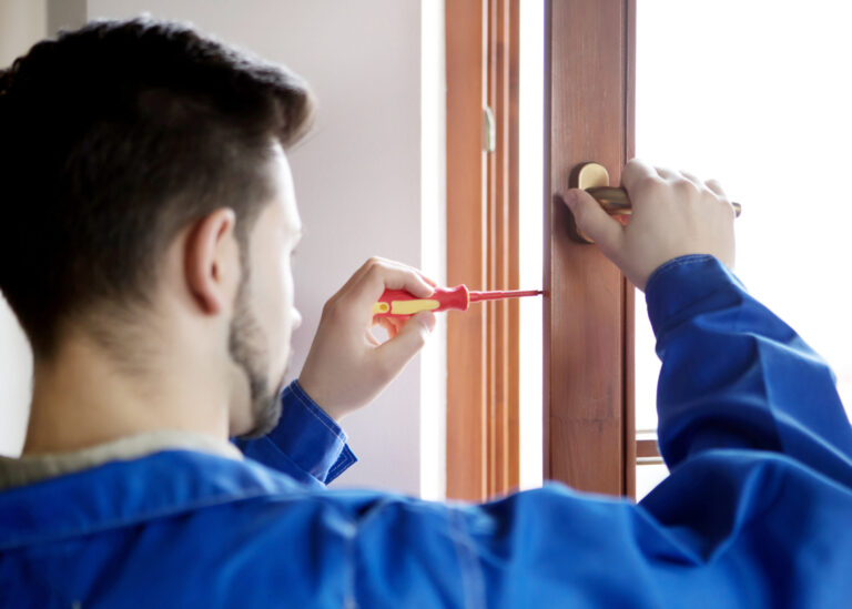 Young handyman repair window with screwdriver.
