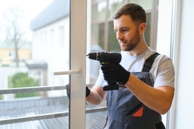 a man using a drill to drill a window